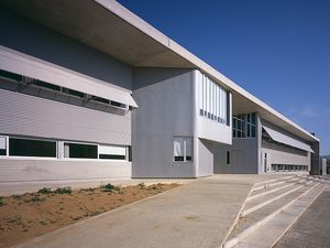 Modern architectural details of Fontajau High School, showcasing its sleek lines and large windows under a clear blue sky.