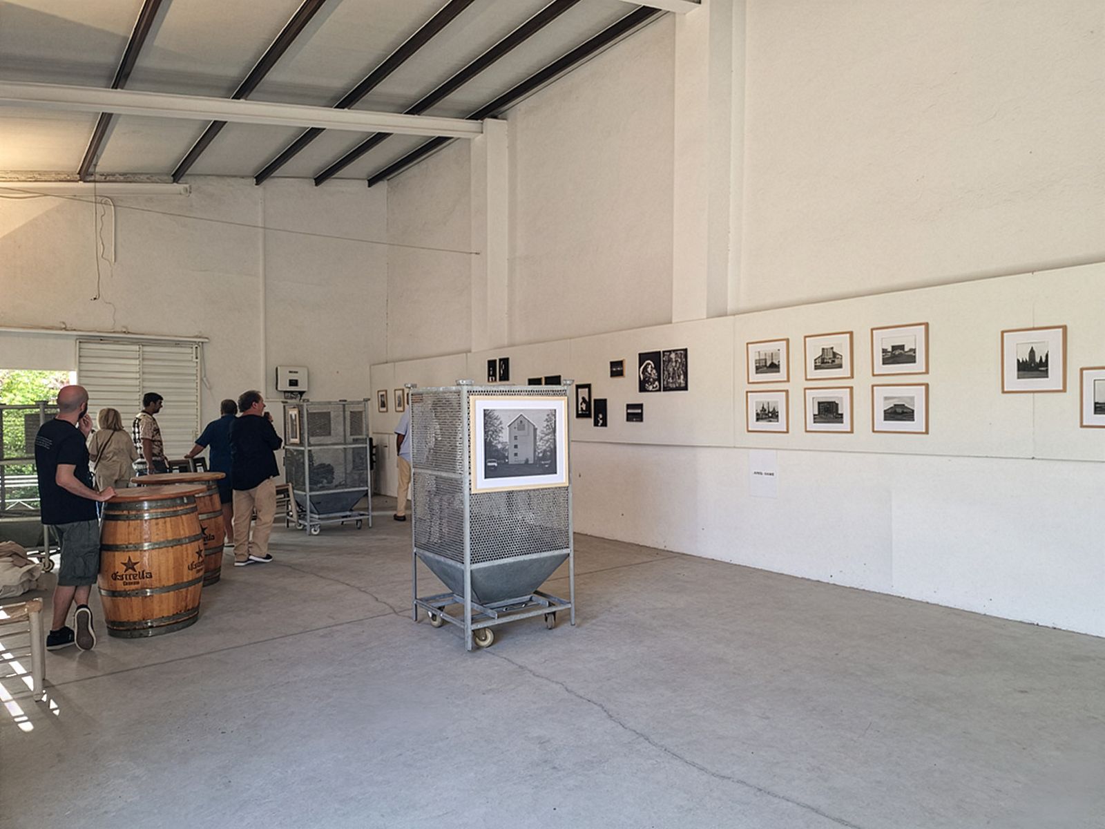 Guests viewing photographs at an exhibition in an open, industrial gallery space.